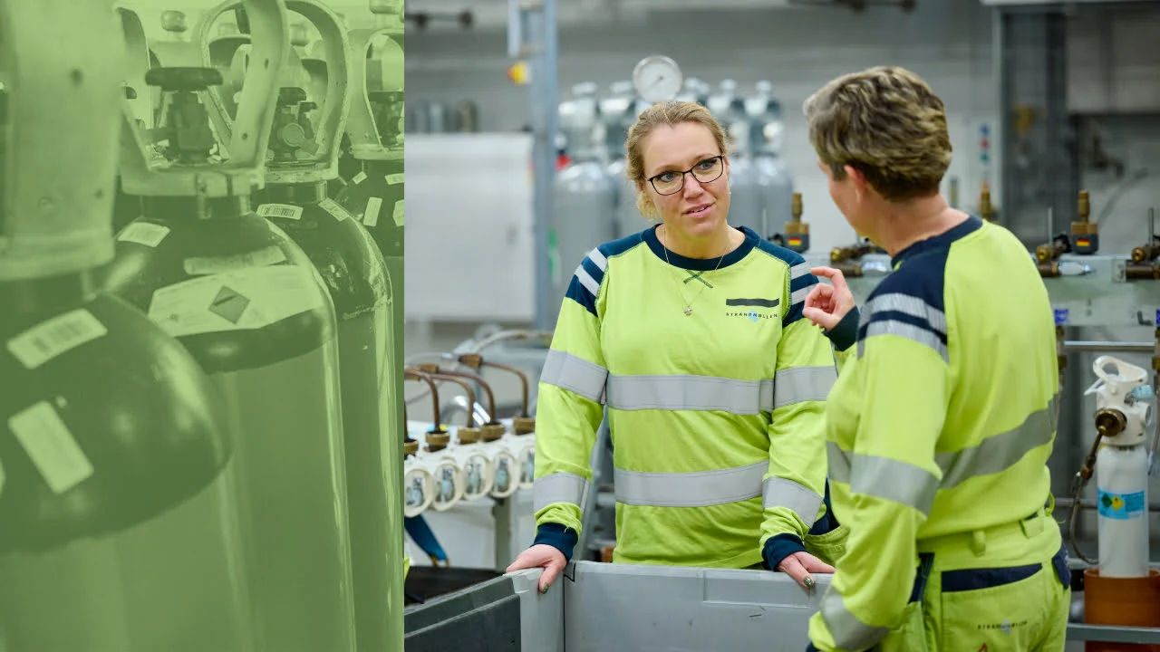 Glade medarbejdere på fabrik mellem flasker snakker om arbejdsplads. Sikkert arbejde i gas industri. 